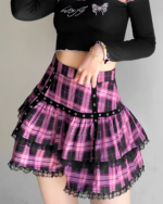 Model wearing a pink plaid mini skirt with a ruffled hem and lace detailing, part of a Mall Goth aesthetic.