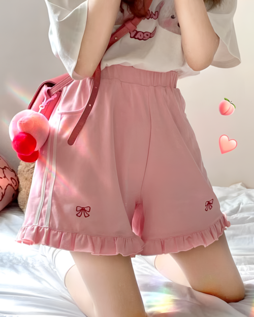 Pink Yume Kawaii shorts with ruffles and bow details, worn by a person.