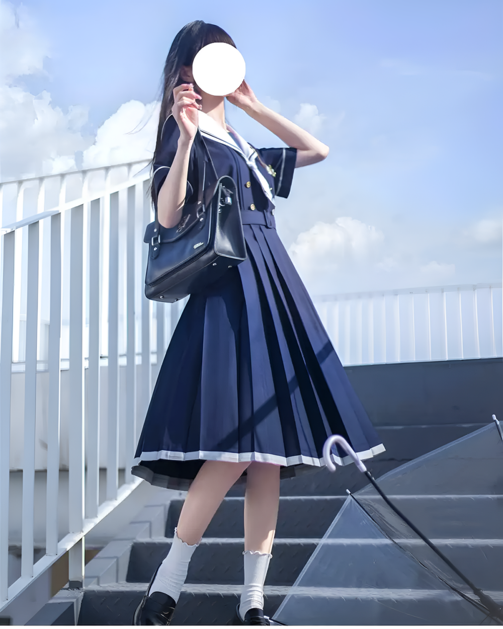 A blue sailor uniform dress (seifuku) with a black bag and white socks, outdoors.