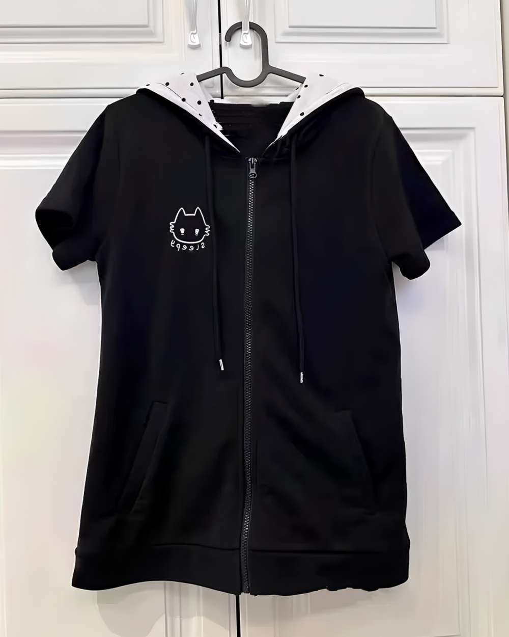 Black short-sleeved hooded t-shirt with a Sleepy Neko design. Zippered front and kangaroo pockets.