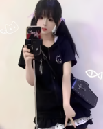 Person wearing a black Sleepy Neko short sleeved hooded t-shirt. Includes a cat graphic and zip-up design.