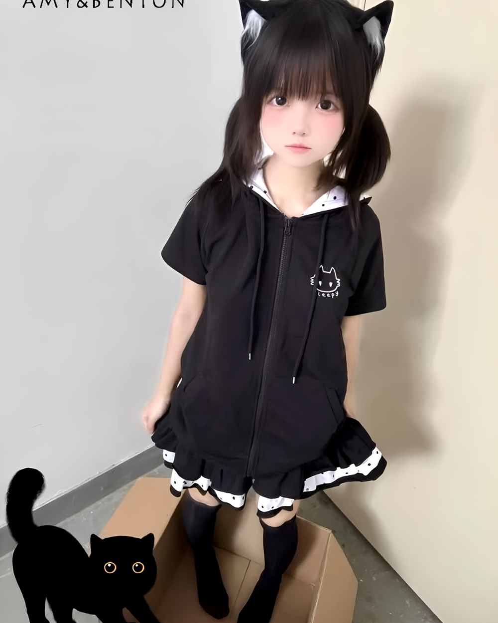 Woman wearing a black short sleeved hooded t-shirt with a Sleepy Neko cat design. A black cat is visible in the corner.