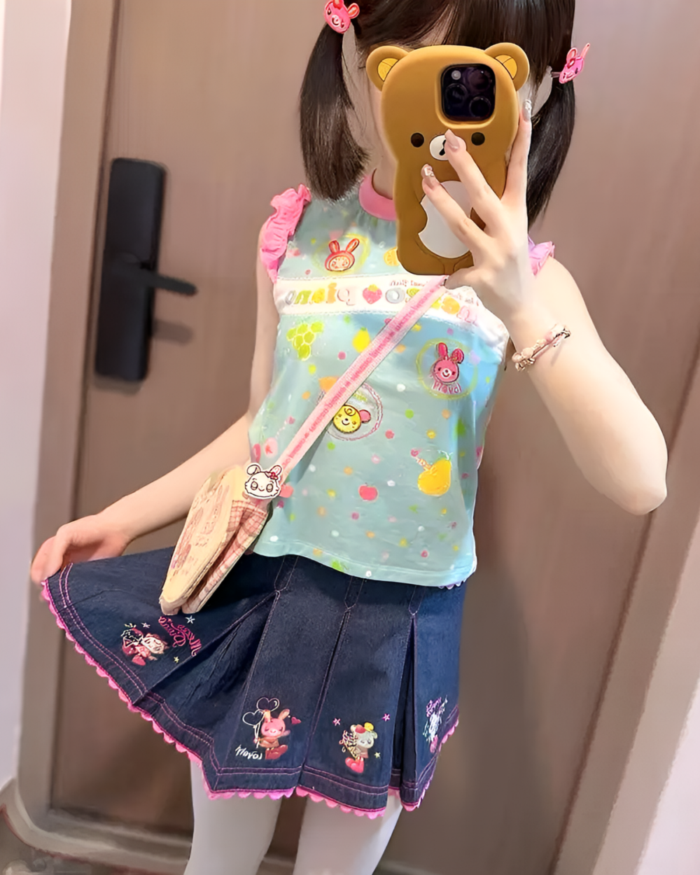 Girl wearing a sleeveless Mezzo Piano top in light blue with embroidered details and a denim skirt.