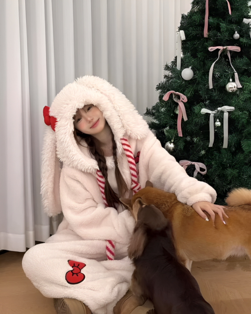 Woman wearing a white Slumber Bow-Bunny Ribbon kigurumi, a cozy bunny kigurumi pajamas, with a dog.