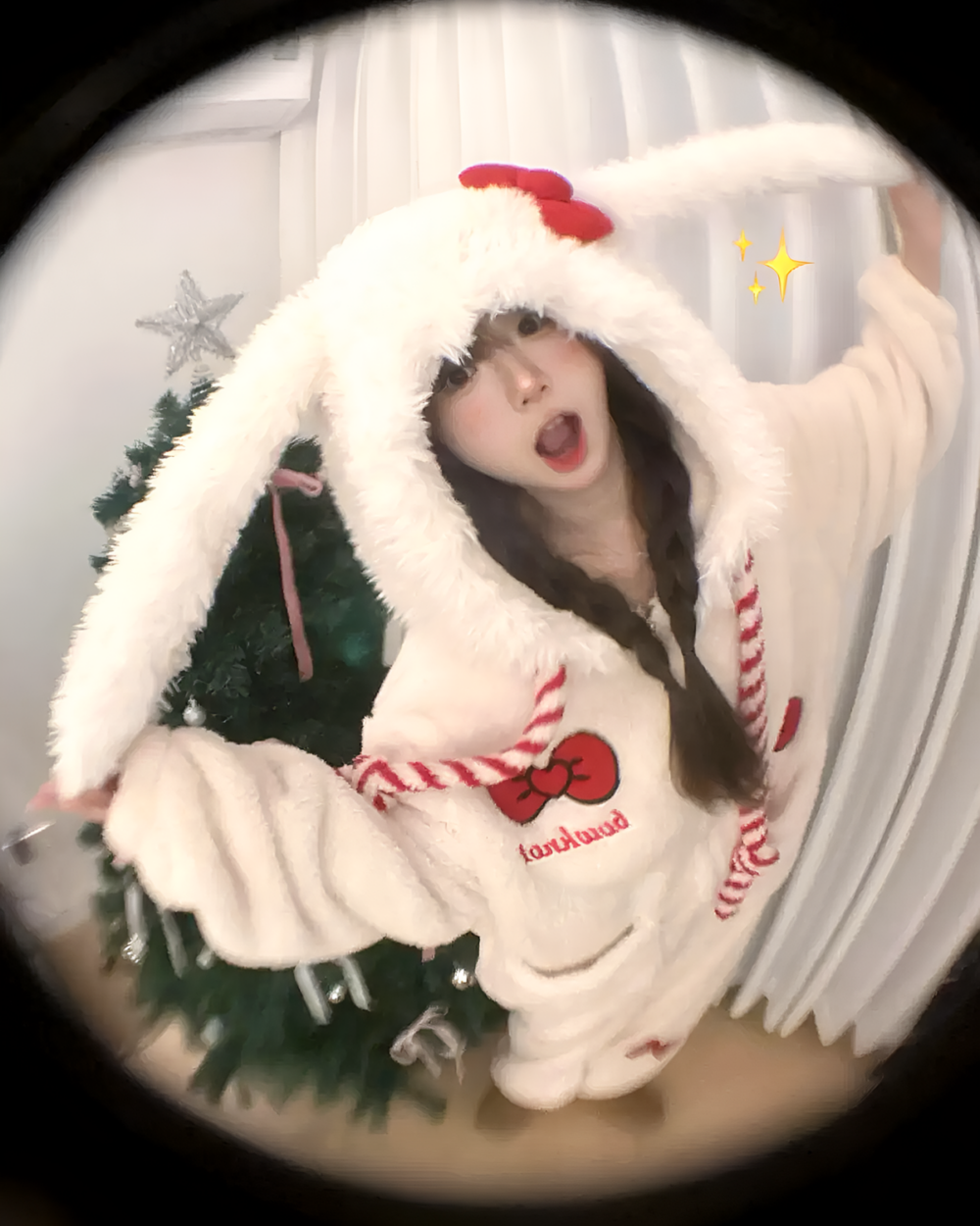 Person wearing a white Slumber Bow-Bunny Ribbon Kigurumi Pajamas, a fluffy bunny kigurumi with a red ribbon and hood.