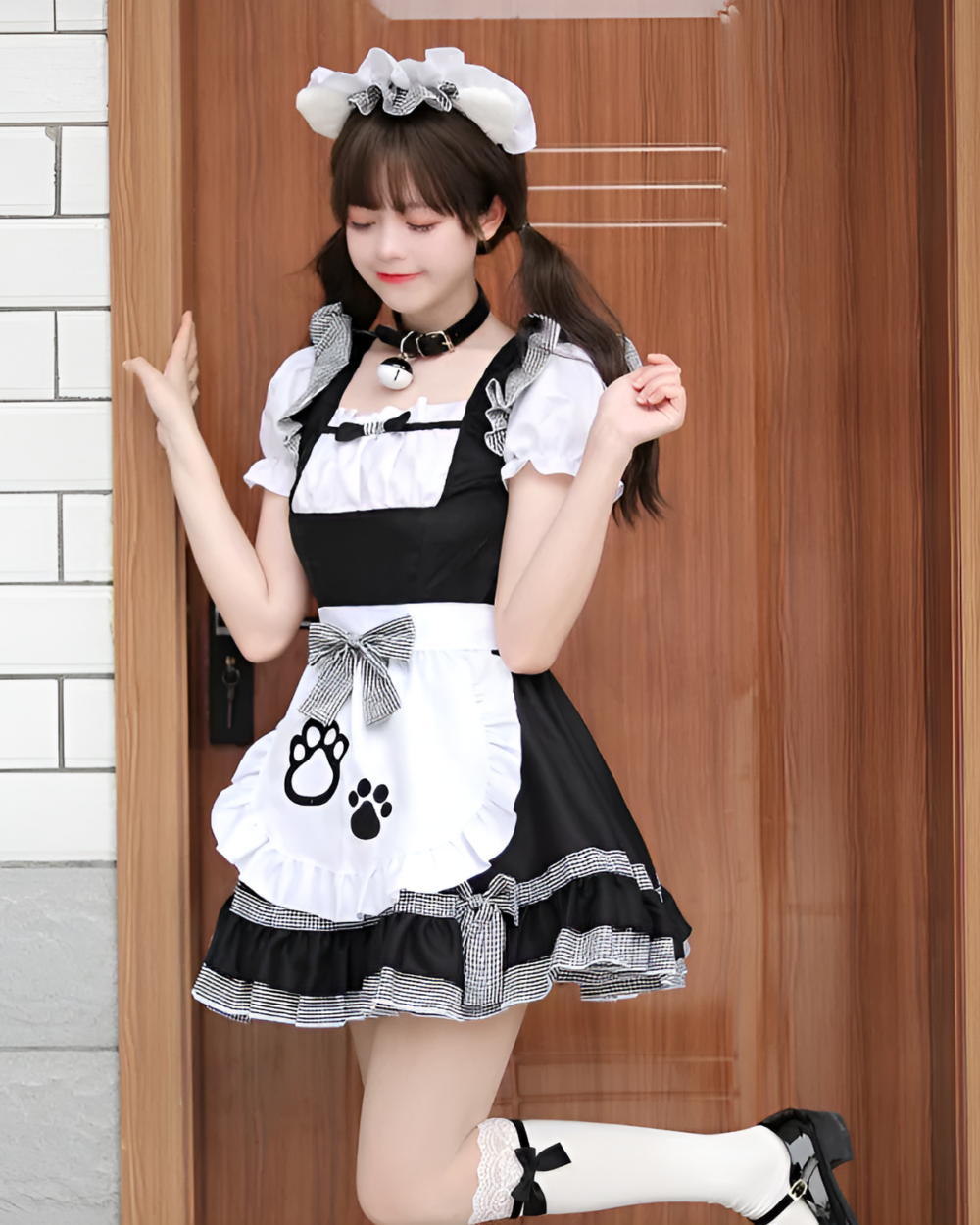 A young woman wearing a Soft Girl Maid Dress - Paw Prints Edition, posing outdoors with a matching headband and accessories.