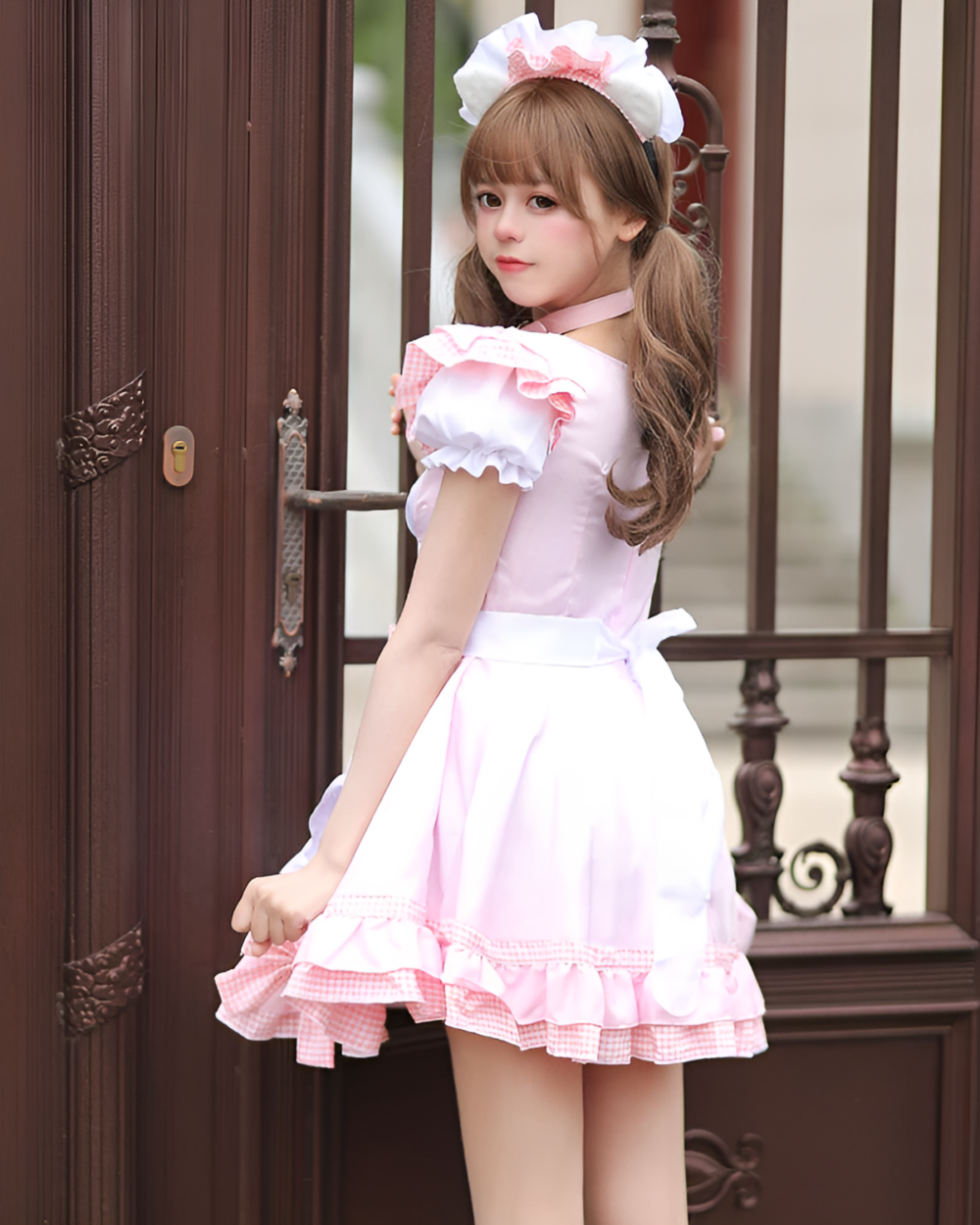 Girl wearing a pink Soft Girl Maid Dress - Paw Prints Edition with a white apron and headband.