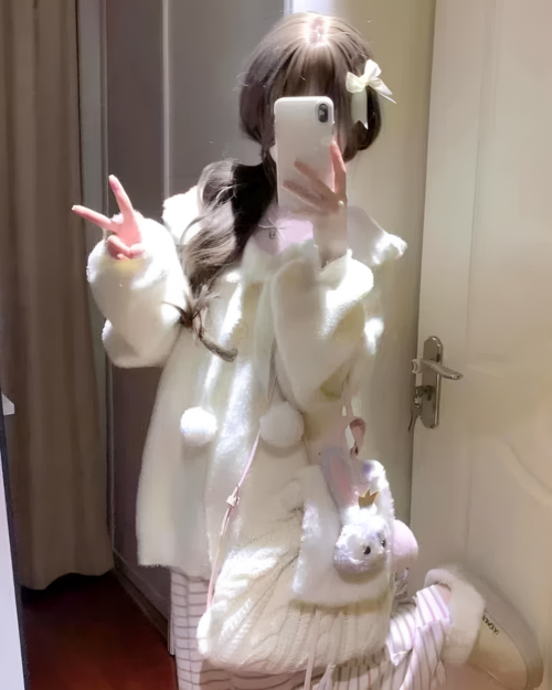 Person wearing a white soft girl sweater with rabbit accessories.