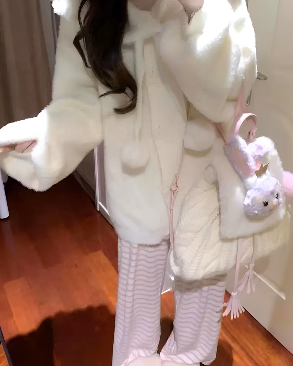 White soft girl sweater with pom-poms and plush toys.