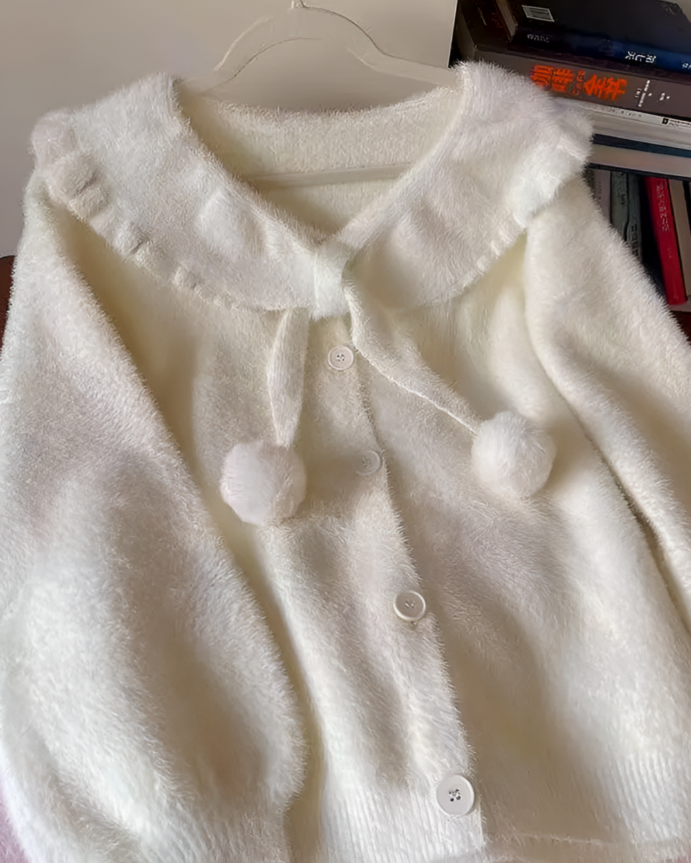 White soft girl sweater with a round collar and button closures.