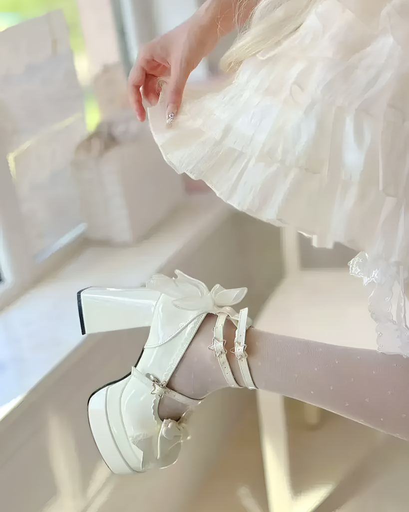 Close-up of white Starlit Lace-Bow Mary Janes with star details and a platform heel, styled with socks.
