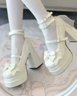 White platform heels featuring a delicate lace-bow detail. These are the Starlit Lace-Bow Mary Janes with a star applique.
