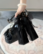 Close-up of black Starlit Lace-Bow Mary Janes with a platform heel and large bow detail. Size 31 is visible.