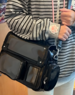 Black Korean Edition ita bag with clear window for displaying collectibles, worn as a crossbody bag.