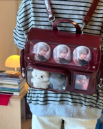 Korean Edition ita bag with clear pockets displaying character photos and accessories. Black, schoolbag style.