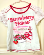 Kawaii graphic tee featuring Strawberry Flakes design, artificial strawberry flavor, and a pink & white pattern.