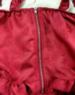 Close-up of a maroon Strawberry Parfait Dress featuring a zipper and patterned fabric.