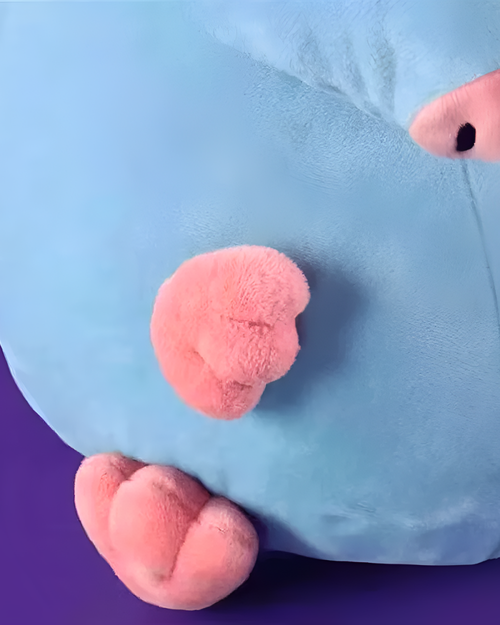 Close-up of a blue Stupid Rat Plushie with pink ears and tail.