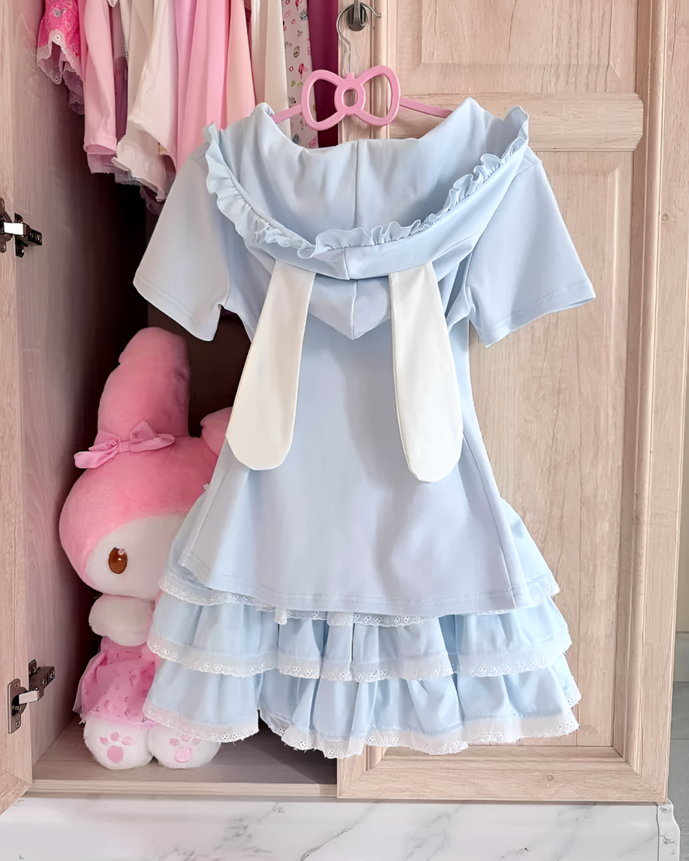Blue Sugarcloud Ruffle-Zip Coord hanging in a closet, a cute Yume Kawaii Coord with ruffle details.