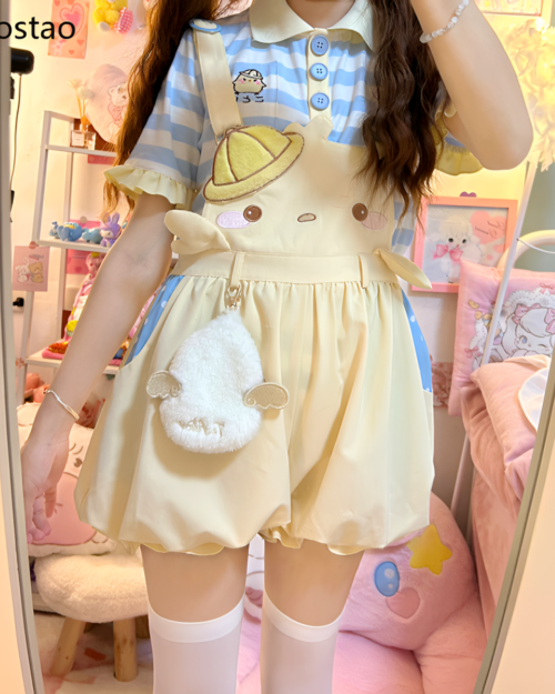 Model wearing a cute yellow suspender outfit with a sun and moon design, featuring a short-sleeved top and overall skirt.