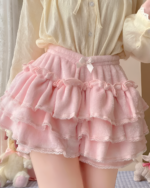 A pink Sweet Lolita Plush Skirt with ruffles and a bow, shown on a person.