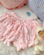 Close-up of a pink Sweet Lolita Plush Skirt with ruffles and lace trim on a rug.