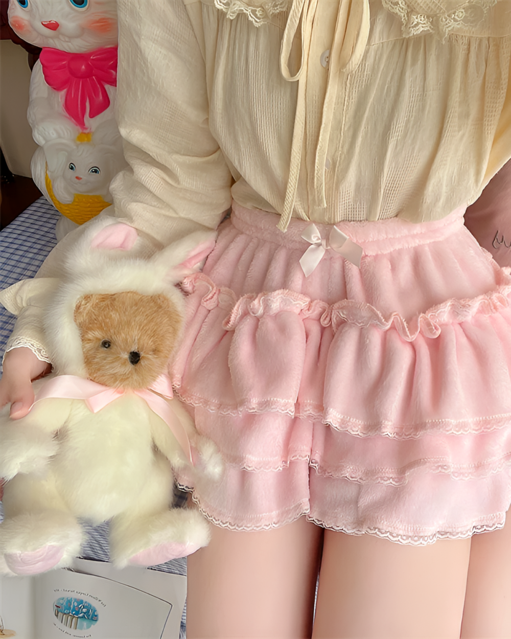 Close-up of a pink Sweet Lolita Plush Skirt with lace trim and ruffles, alongside plush toys.