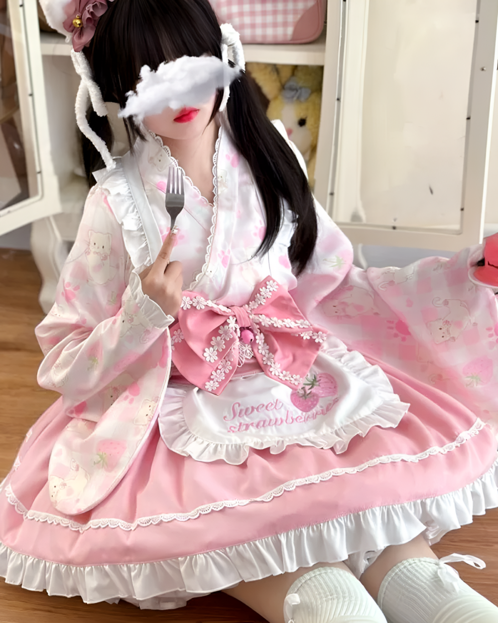 A pink sweet lolita dress featuring strawberry and bear motifs, worn by a model.