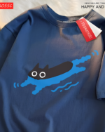 Close-up of a navy blue Kuro Neko T-Shirt featuring a graphic of a black cat swimming in blue waves.