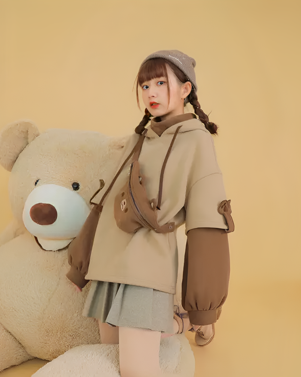 Model wearing The Bearcore hoodie with a teddy bear and crossbody bag.