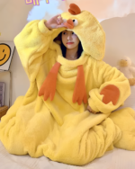Woman wearing a yellow Chicken Kigurumi, a plush animal onesie with a hood and feet. Comfortable costume.