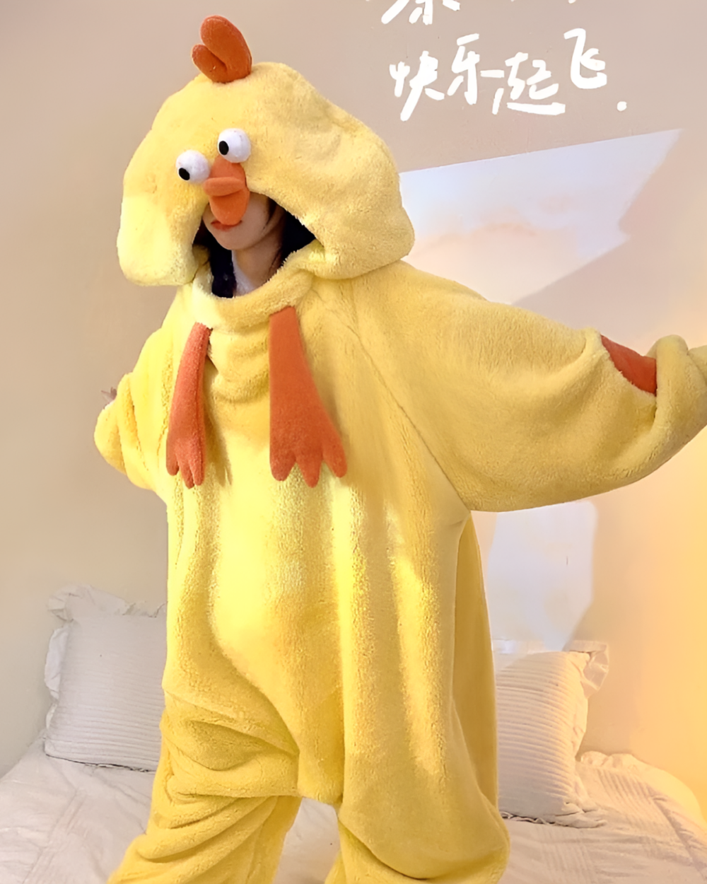 Person wearing a yellow Chicken Kigurumi costume with a hood and orange feet. Cozy and fun oversized animal pajama.