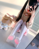 Person wearing a beige Doggy Sweatshirt with bear ears and pink socks, posing for a self-portrait.