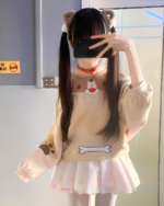 A person wearing a beige Doggy Sweatshirt with a bear hoodie design, styled with a pink skirt.