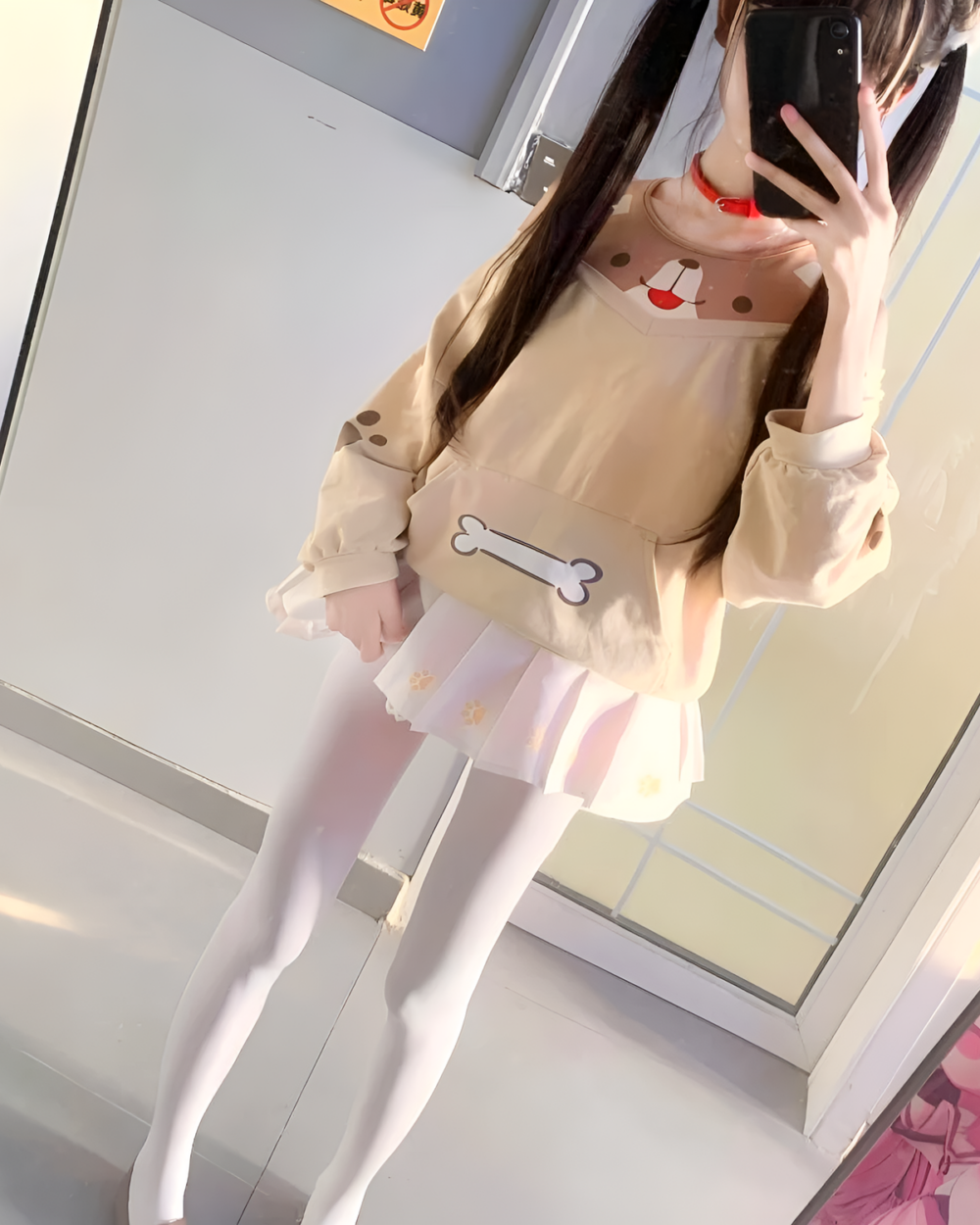 Person wearing a beige doggy sweatshirt with bone detailing and white skirt. Stylish doggy sweatshirt with unique design.
