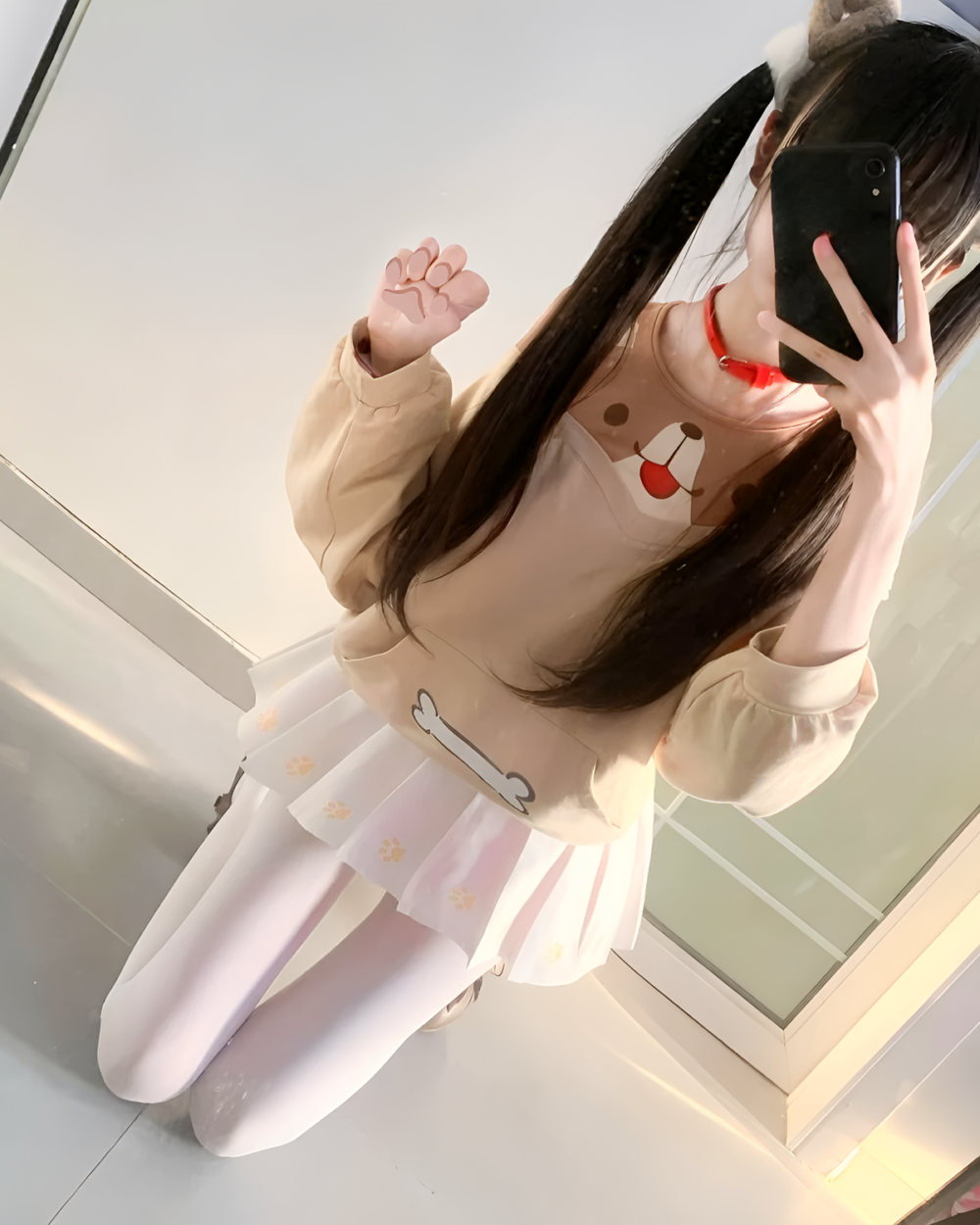 Person wearing a beige Doggy Sweatshirt with a dog face design and a white skirt. The sweatshirt features paw print details.