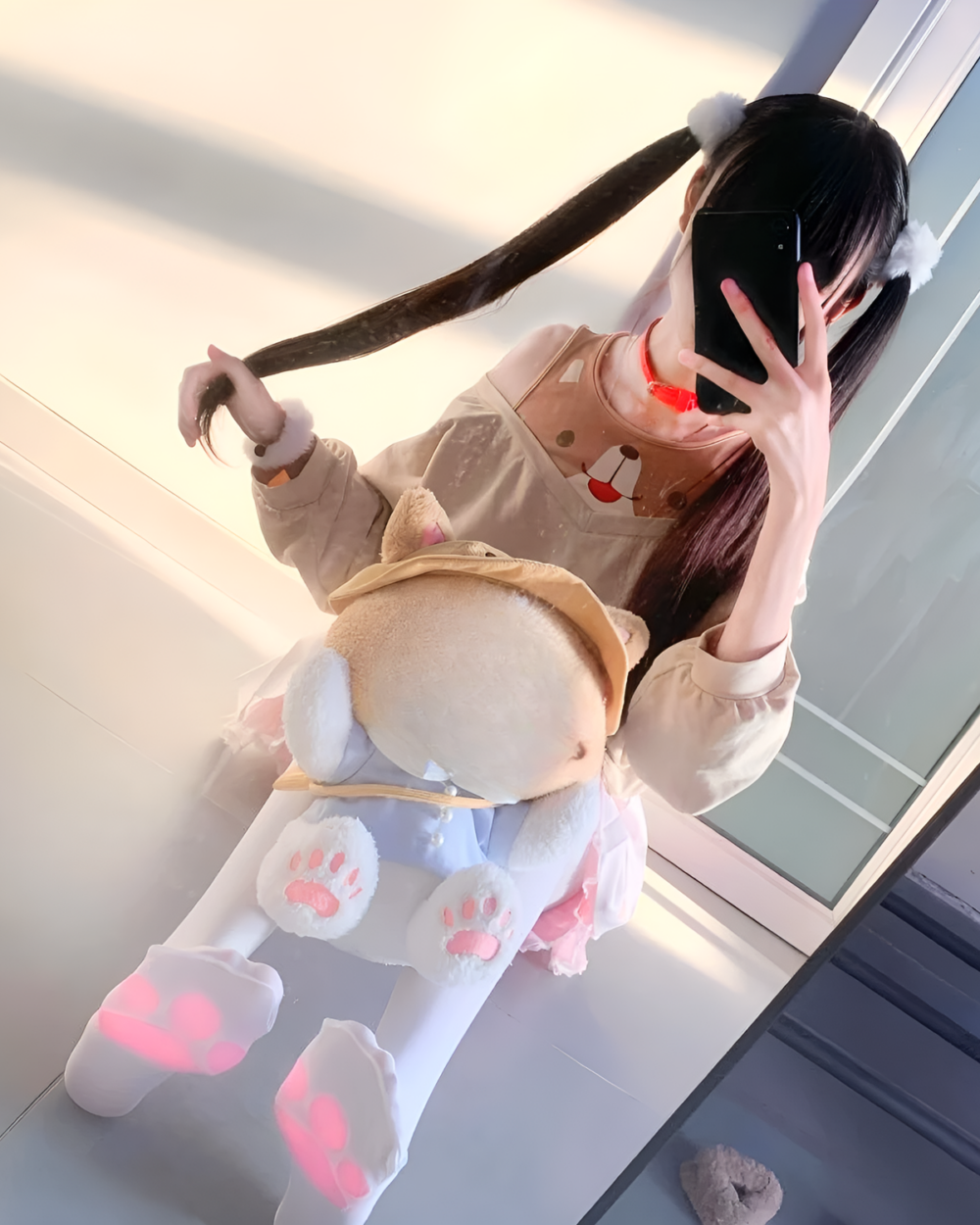 Person wearing a beige Doggy Sweatshirt with bear details and matching paw print socks, taking a selfie.