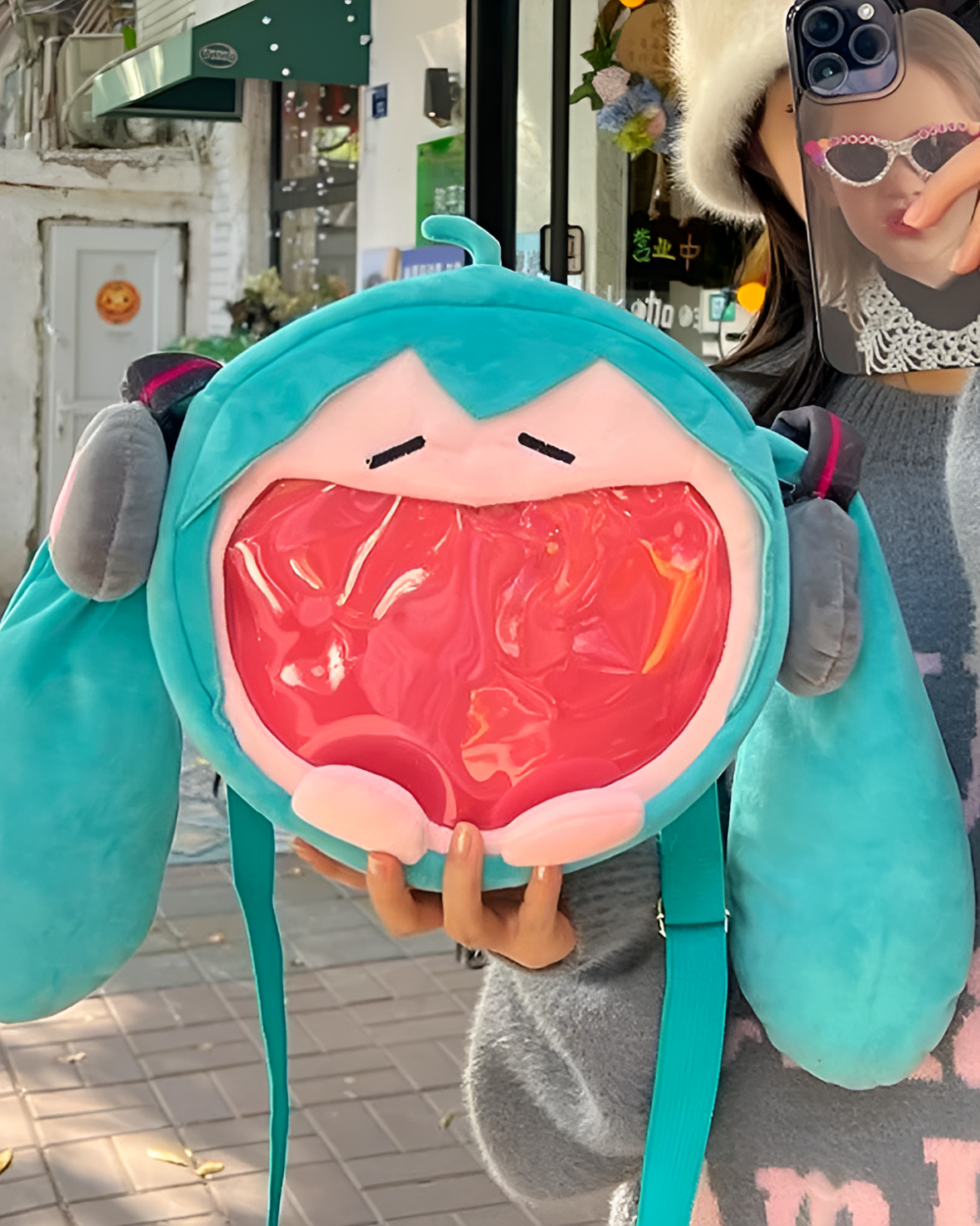 The Incredible Miku Plush Bag, a teal plush crossbody bag with a large, smiling mouth.