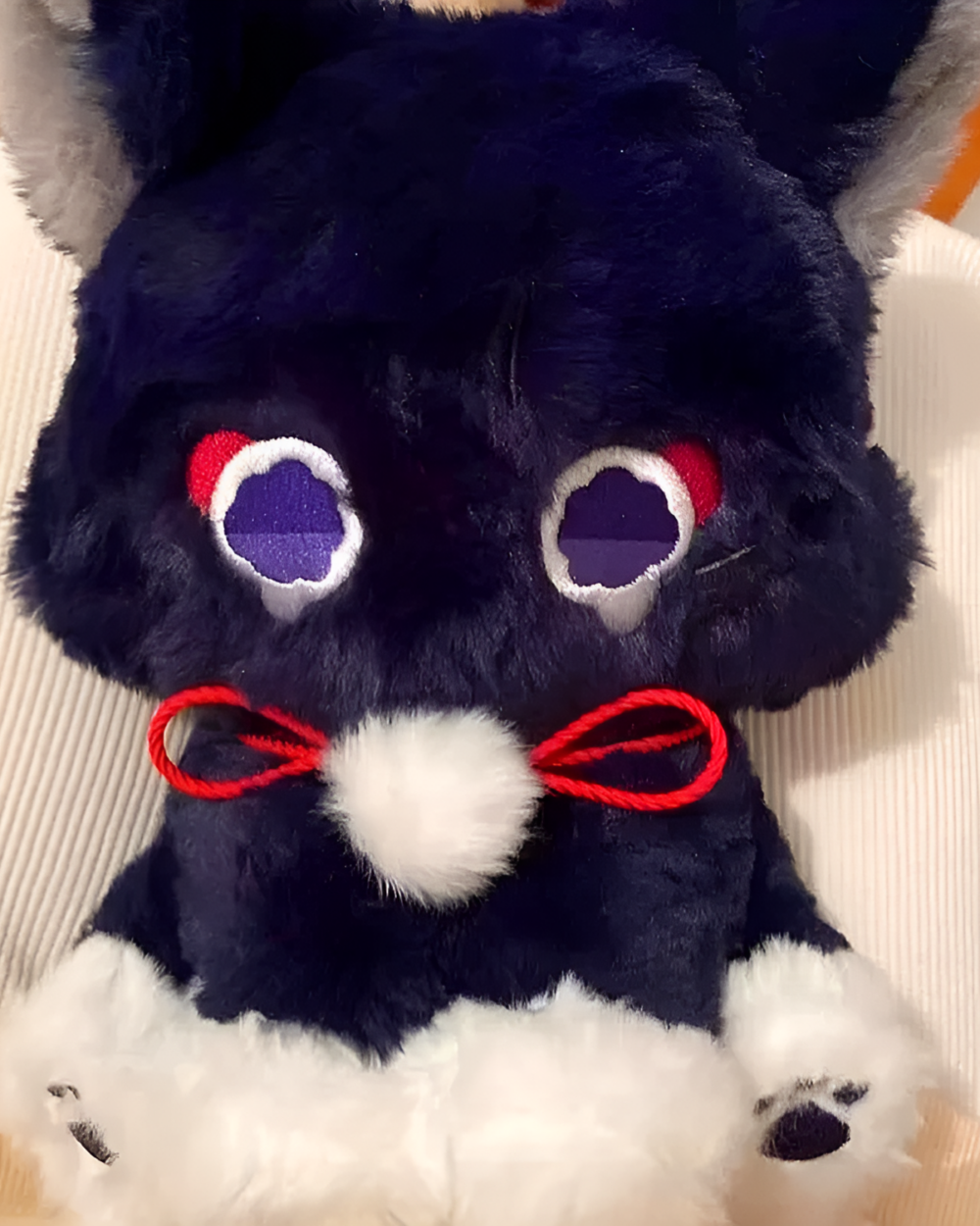 Close-up of The Scarameow Plushie featuring red accents and white paws. A detailed Scarameow plushie for fans.