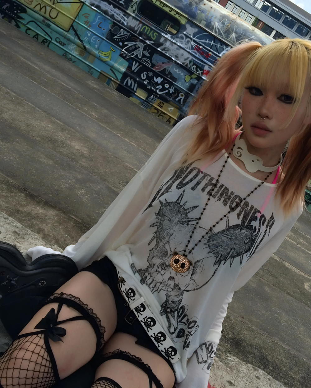 Person wearing a white Transluscent Nothingness T-Shirt with a graphic print and black lace socks.