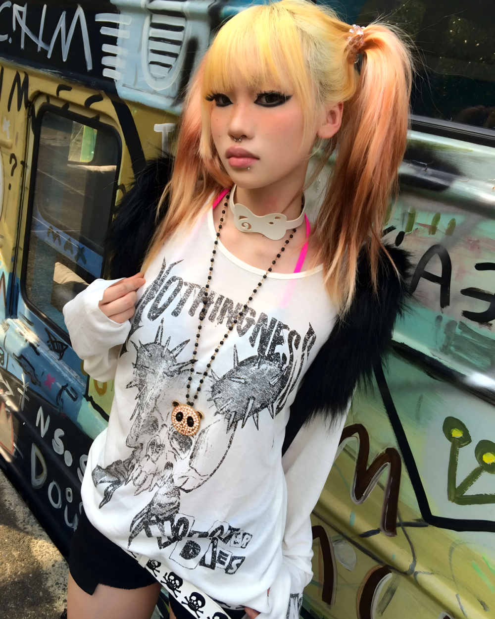 Person wearing a white long-sleeve Transluscent Nothingness T-Shirt with a graphic design in an urban setting.