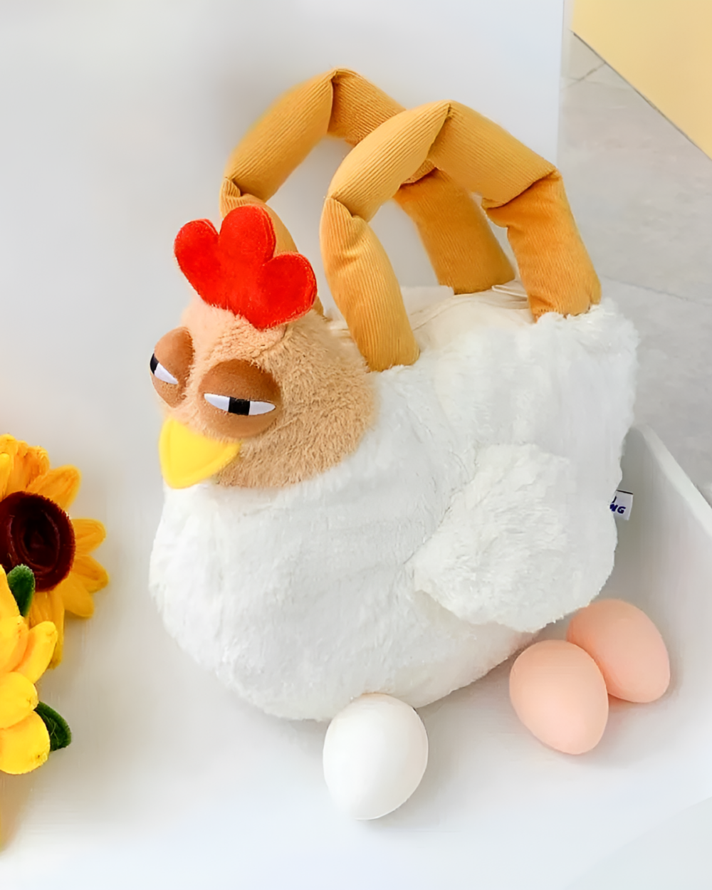 Ugly Chicken Plush Handbag with eggs, a unique plush toy designed as a handbag. Features a white fluffy body and yellow details.