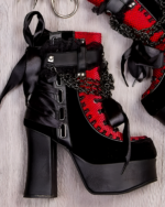 Close-up of Vampyra platform goth boots in red and black, featuring chain and ribbon details. High platform sole and lace-up design.