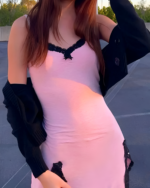 Woman wearing a pink Velvet Vamp Mini Dress with black lace trim and a black cardigan.
