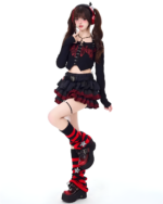 Model wearing a black and red Venom Heart Ruffle Skirt set with a ruffled mini skirt and a cropped top.