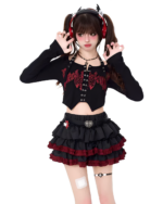 Model wearing the Venom Heart Ruffle Skirt set, a black long sleeve and ruffled mini skirt with red accents.
