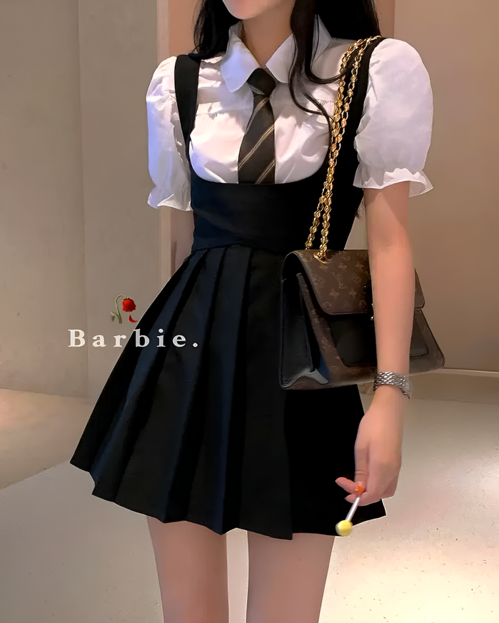 Woman wearing a black and white suspender skirt set with a blouse and a handbag.