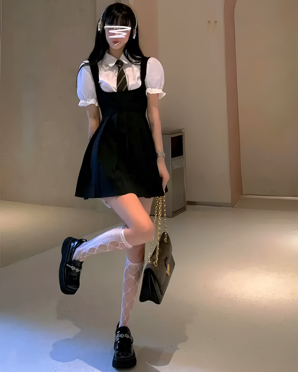 Woman wearing a black suspender skirt set with a white blouse and platform boots. Includes fishnet socks.