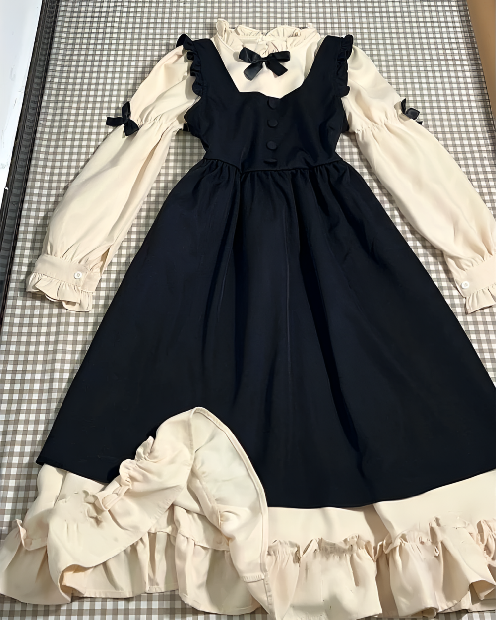 Cream and black vintage midi cottagecore dress with ruffled sleeves and bow detail.