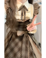 Close-up of a brown and beige cottagecore dress with ruffles and a bow detail.